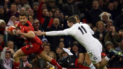 Rhys Webb of Wales, left, evades a tackle by England's Jonny May on his way to scoring a try on Friday night in their Six Nations match. Geoff Caddick / EPA