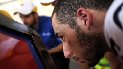 Muhammad El Maud, the driver for the American University of Sharjah team, watches closely as technicians inspect his car. Jes Aznar for The National