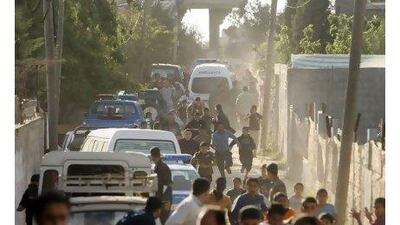 Palestinians run for cover in the Nusseirat refugee camp in the Gaza Strip during a shoot-out between Hamas security forces and suspects in the killing of Italian activist Vittorio Arrigoni.