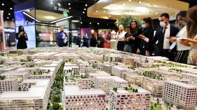 Visitors at the Arada stand look at the model of Aljada development area in Sharjah at Cityscape Global in Dubai on November 9, 2021. Pawan Singh / The National