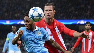 Manchester City’s Raheem Sterling chases down the ball against Sevilla’s Grzegorz Krychowiak on Wednesday during their Champions League contest. Oli Scarff / AFP