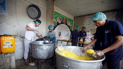 Cooks pack food at a charity kitchen, which gives free food rations for the poor, in Sanaa, Yemen April 20, 2018. REUTERS/Mohamed al-Sayaghi