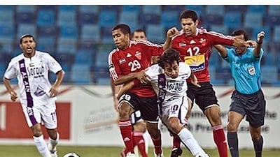 Al Ahli's Ali Hussain, No 29, and Al Ain's Chilean playmaker, Jorge Valdivia, No 10, battle for possession during yesterday's Super Cup match at Dubai Sports City.