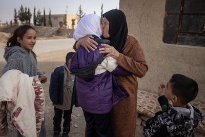 Umm Marwan (4th-L) reacts as she meets her grandchildren for the first time after her son Ahmed Muhammad Al-Nawa ,36, returned from Lebanon to his family’s home in the village of Harran for the first time in 10-years, on December 21, in Damascus, Syria. Ahmed, was imprisoned and tortured by the regime for a year and half in the Mezzah Military Prison in 2012-2013. Getty Images