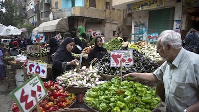 Egypt has been wrestling with a currency crisis that economists blame on an overvalued pound. Pictured, Egyptians buy vegetables from a traditional market in old Cairo. AFP