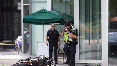 A police officer photographs a motorcycle after a female stunt driver working on the movie Deadpool 2 died after a crash on set, in Vancouver, B.C. Darryl Dyck / The Canadian Press via AP