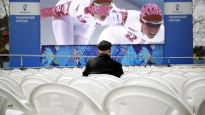 A man watches a broadcast of the speed skating competition from the nearby 2014 Winter Olympics on a big screen at an amusement park on Saturday, February 22, 2014, in Adler, Russia. David Goldman / AP Photo