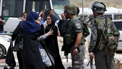A Palestinian woman argues with an Israeli border policeman near the scene where two Palestinians where shot dead by Israeli forces near Qalandia checkpoint in the West Bank. Ammar Awad / Reuters