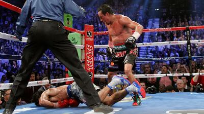 Juan Manuel Marquez, right, steps away after knocking out Manny Pacquiao of the Philippines, bottom, in the 6th round during their welterweight figh. Steve Marcus / Reuters