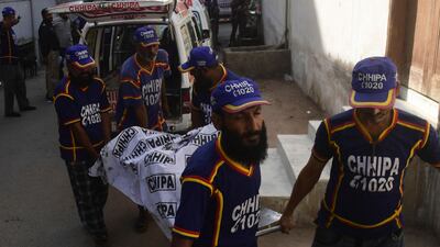Volunteers move a person injured in the suicide blast that killed at least three Chinese citizens in Karachi. AFP
