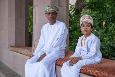 An Omani man and boy wear national dress. Unsplash