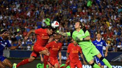 Liverpool's Dejan Lovren heads the ball clear from danger. Mark Ralston / AFP