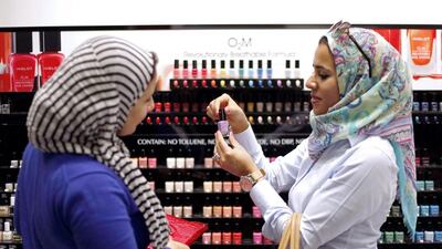 Two Egyptian women buy breathable nail polish from a store in Dubai. Cosmetics are among the lifestyle aspects included in the plan to create an Islamic economic centre in the emirate. Reuters