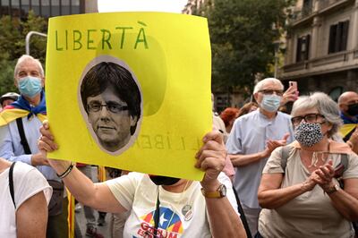 A demonstrator holds a portrait of Carles Puigdemont in front of the Italian consulate in Barcelona on Friday after his arrest. Photo by LLUIS GENE / AFP