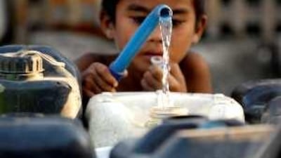 A Filipino boy fills his water container in a Manila street. The Philippines is currently suffering severe drought brought on by the El Niño effect.