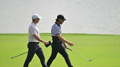 Rory McIlroy and Tommy Fleetwood walk on the green during the first day of the Dubai Desert Classic. AFP