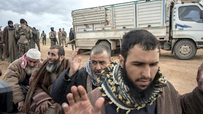 Men suspected of belonging to ISIS are screened by Syrian Democratic Forces after fleeing from the last pocket of territory held by the group outside Baghouz, Syria. Campbell MacDiarmid / The National