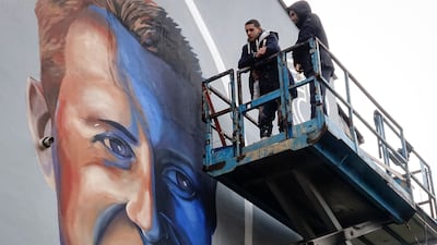 Benjamin Cengic next to his mural of Michael Schumacher in Sarajevo, Bosnia. AP