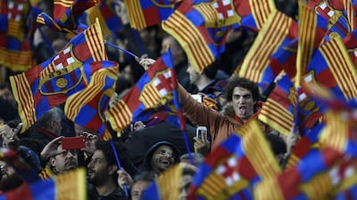Barcelona's supporters wave flags during their team's Champions League match against Manchester City on Wednesday night at the Camp Nou. Lluis Gene / AFP