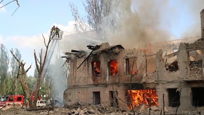 Firefighters hose down a building after the Russian attack in Dnipro, Ukraine. AP
