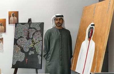 Saoud Al Dhaheri and a self-portrait he has made while in residency at the Cultural Foundation. Khushnum Bhandari for The National