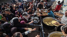 Displaced Palestinians gather to receive food at a charity kitchen in the Nuseirat refugee camp in the central Gaza Strip on December 20. AFP