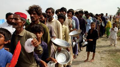 Flood-affected people wait for food distributed by army troops in a flood-hit area of Punjab, Pakistan, on August 27. AP