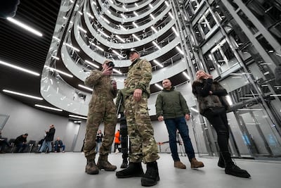 Visitors wearing military camouflage talk in the PMC Wagner Centre. AP