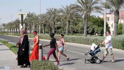 Jon Edwards (white t-shirt) crosses the road in Al Ghadeer. Pawan Singh / The National