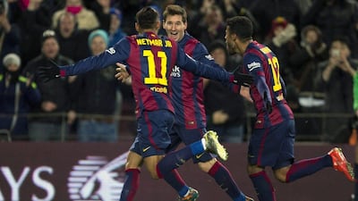 Lionel Messi, centre, celebrates with Neymar, left, and Rafinha, after his stunning strike handed Barcelona a 3-2 lead. All three players pictured were on the scoresheet on Sunday night. Alejandro Garcia / EPA