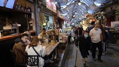 People eat at a restaurant in Jerusalem's main market after authorities reopened restaurants, bars and cafes to "green pass" holders (proof of having received a Covid-19 vaccine), on March 11, 2021.AFP