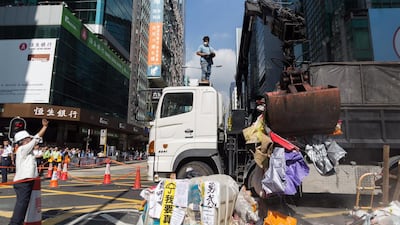A worker operates a crane to remove barricades in a blocked section of Argyle Street in Mong Kok. Hong Kong bailiffs have been enforcing a court order against a protest camp and have successfully torn down barricades at an intersection in Mong Kok, after a tense face-off with pro-democracy demonstrators. Jerome Favre / EPA
