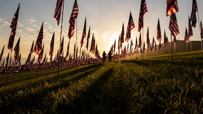 People walk among the flags of the commemorative installation 'Waves of Flags' on the eve of the 20th anniversary of 9/11 at the Pepperdine University in Malibu, California. EPA