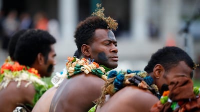 Men in traditional attire wait for the royal couple's arrival.
