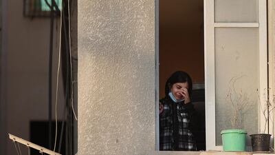 A Palestinian girl cries as she looks out from her home's window at destroyed neighbouring buildings in a residential area of Gaza City, following Israeli air strikes. AFP