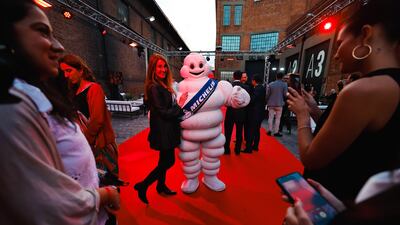 A guest poses with the Michelin Man mascot at a Michelin restaurant guide event in Buenos Aires, Argentina. EPA