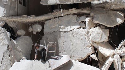 A Syrian girl collects her belongings from rubble on April 21 after her building was reportedly destroyed in an air strike by government forces in the northern city of Aleppo. Baraa Al Halabi / AFP Photo