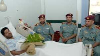 Rashid Mohammed, 43, in Al Qassimi hospital yesterday. Visitors, from right: Abdullah Mubarak al Dukhan, deputy director of Sharjah Police; Abdullah Sultan, head of public relations, and Saleem al Mugarab, head of administration.