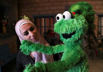 Puppeteer Leen Sorsok stands near 'Ameera' the new muppet character who uses a purple wheelchair or crutches to get around owing to a spinal cord injury, on the set of the children's TV show 'Ahlan Simsim'. Reuters