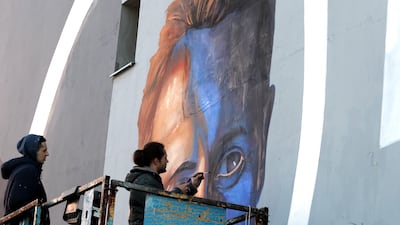 Bosnian artists work on a mural of Michael Schumacher. The artwork is painted on a side of a building that was partially rebuilt by donations raised by Schumacher after the war in Bosnia. EPA