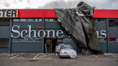 Parts of a roof hang over the facade of a shop. AP Photo