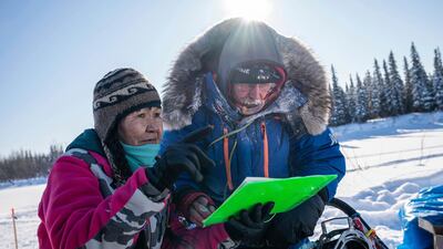 Marty Runkle checks in musher Mitch Seavey at the Nikolai, Alaska, checkpoint during the Iditarod Trail Sled Dog Race. AP