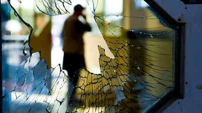 A man is seen through a broken window of a wedding hall after the deadly bomb blast in Kabul. AFP