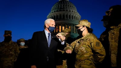 Vice President Mike Pence elbow bumps with a member of the National Guard as he speaks to troops outside the US Capitol. AP Photo