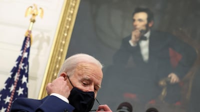 US President Joe Biden adjusts his face mask while speaking about his administration's plans to respond to the economic crisis. Reuters