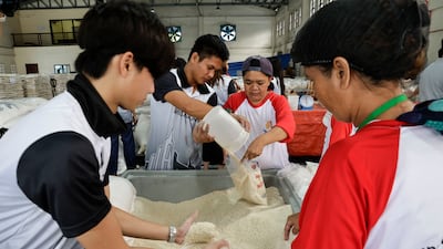 Volunteers and local government assistance beneficiaries work together to pack food boxes intended for relief operations in Pasay City, Metro Manila. EPA