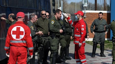 Members of the Hellenic Red Cross check the temperature of Greek riot police officers who wait to enter the Kastanies border crossing area with Turkey's Pazarkule, Greece. REUTERS