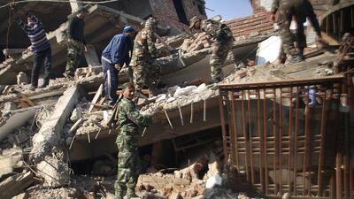 Indian soldiers and residents remove debris from a damaged building after an earthquake in Imphal, the capital of the north-eastern state of Manipur. Bullu Raj / AP Photo