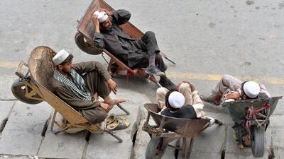 Afghan labourers rest in their wheelbarrows on a street in Jalalabad. AFP