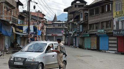 An Indian paramilitary trooper checks a car driver's papers during heightened security and a general strike in Srinagar as the prime minister, Narendra Modi, visited Kashmir state on July 4, 2014. Tauseef Mustafa / AFP